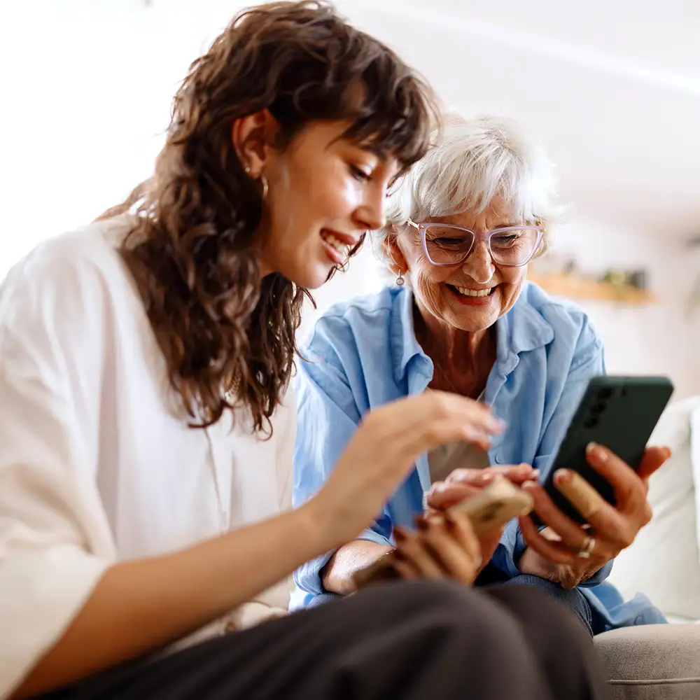 ABOUT Local Loyalty Senior woman with her adult daughter looking at a cell phone