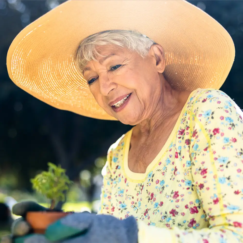 Senior woman gardening wearing a large sunhat